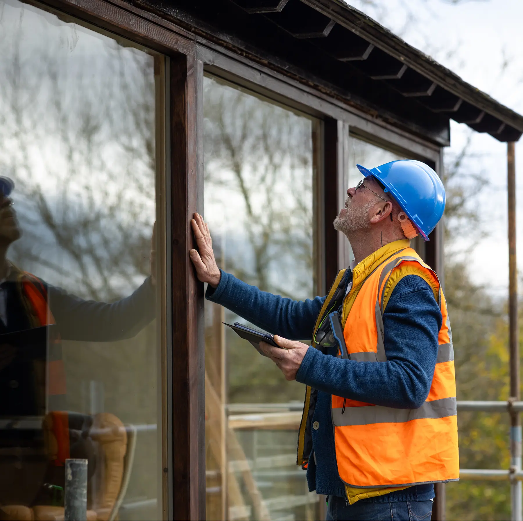 Construction worker inspecting building windows.